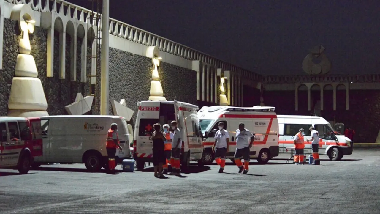 Veh&iacute;culos de Cruz Roja, atienden a varios migrantes a su llegada al muelle de La Restinga tras ser rescatados de una patera el pasado 23 de agosto