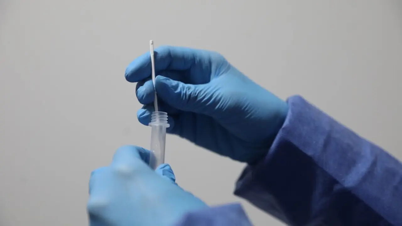 Archivo - Un sanitario sostiene una probeta tras realizar un test de ant&iacute;genos