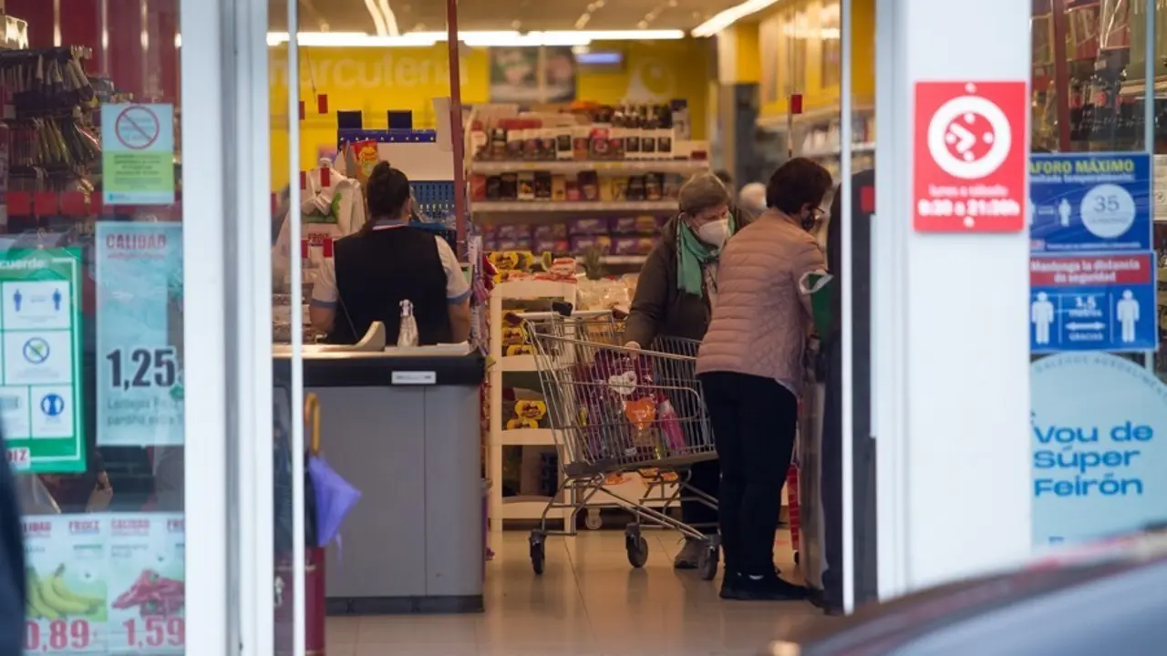 Archivo - Varias personas compran en un supermercado 