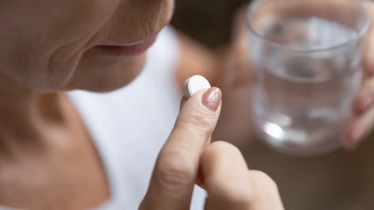 Archivo - Mujer madura tomando una pastilla. Menopausia. F&aacute;rmaco.