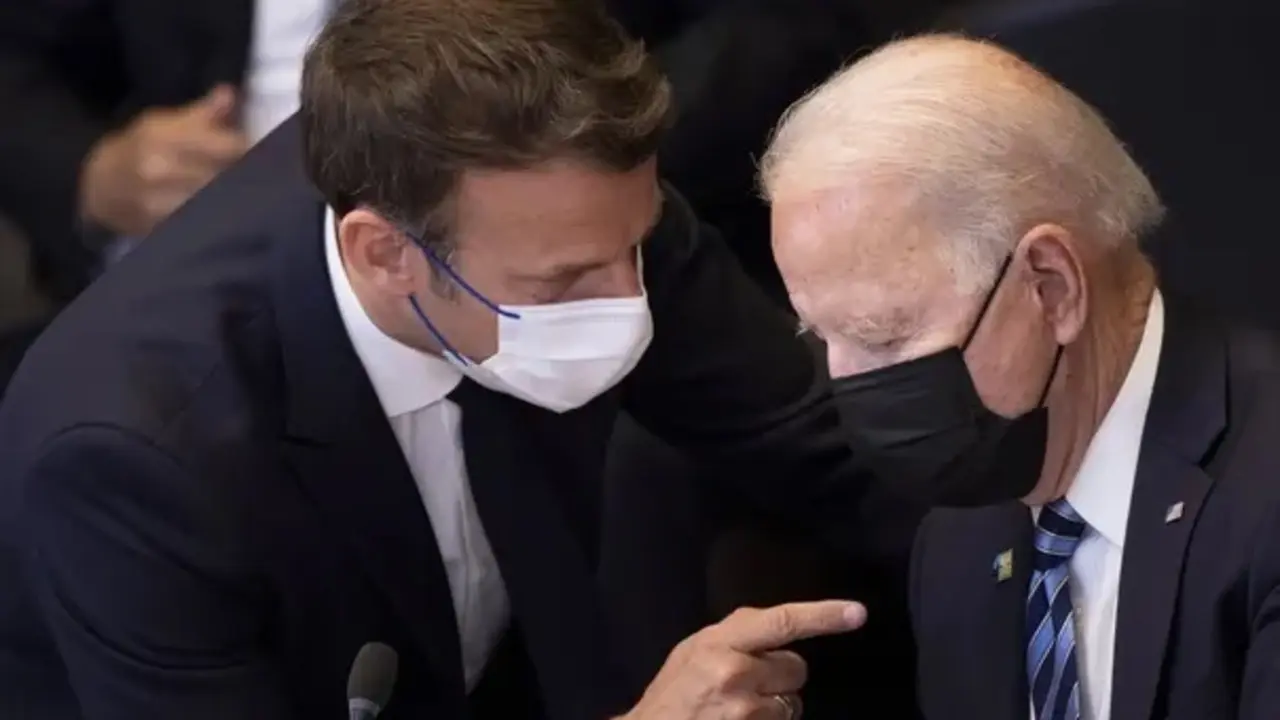 Joe Biden, a la derecha, hablando con Emmanuel Macron en una cumbre de la OTAN. Fotograf&iacute;a: Brendan Smialowski/AP