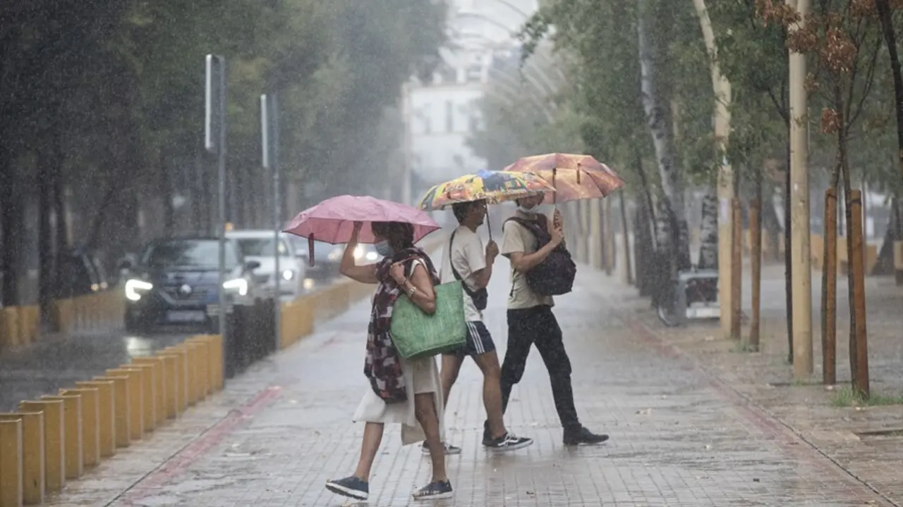 Varias personas caminan bajo sus paraguas durante una tormenta