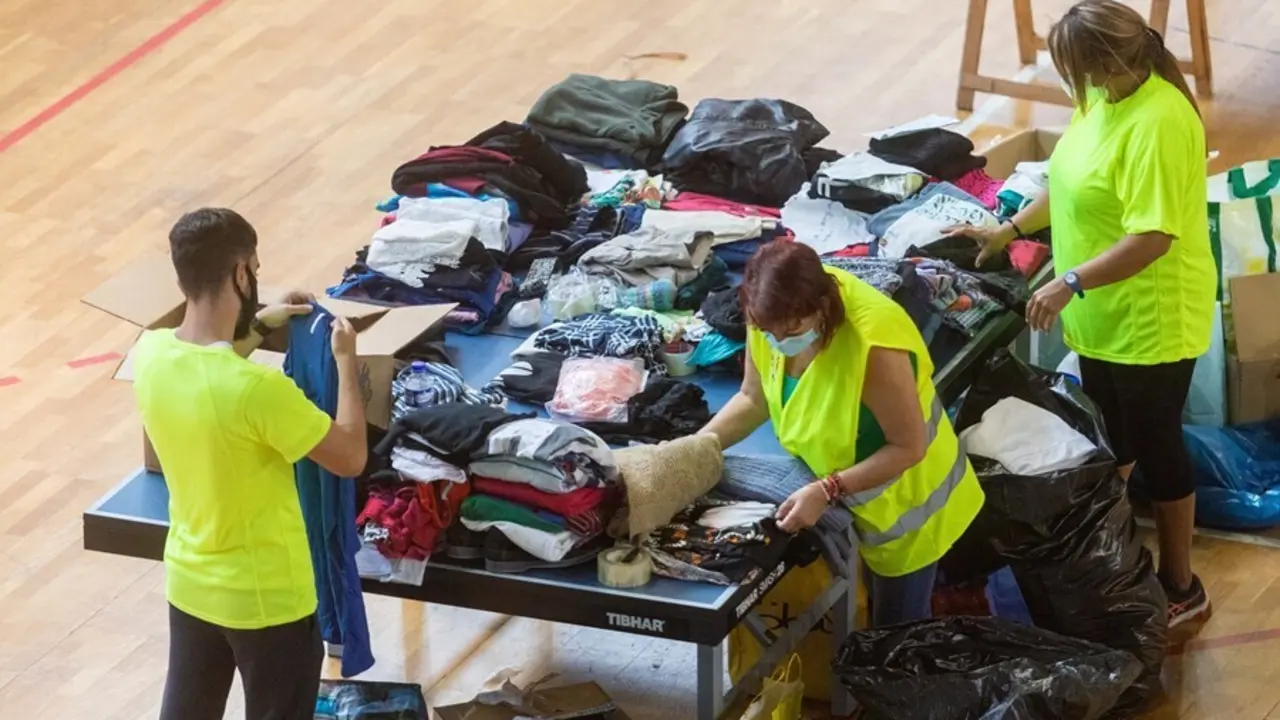 Varias personas colaboran y apilan ropa y objetos en el Polideportivo Severo Rodr&iacute;guez, donde se almacenan donaciones para los afectados por la erupci&oacute;n del volc&aacute;n de &lsquo;Cumbre Vieja