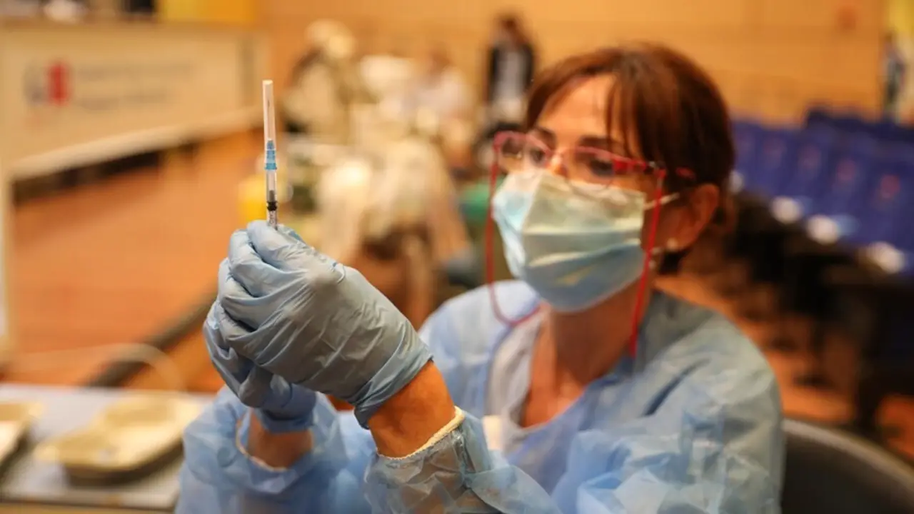 Archivo - Una sanitaria prepara una vacuna contra el coronavirus.