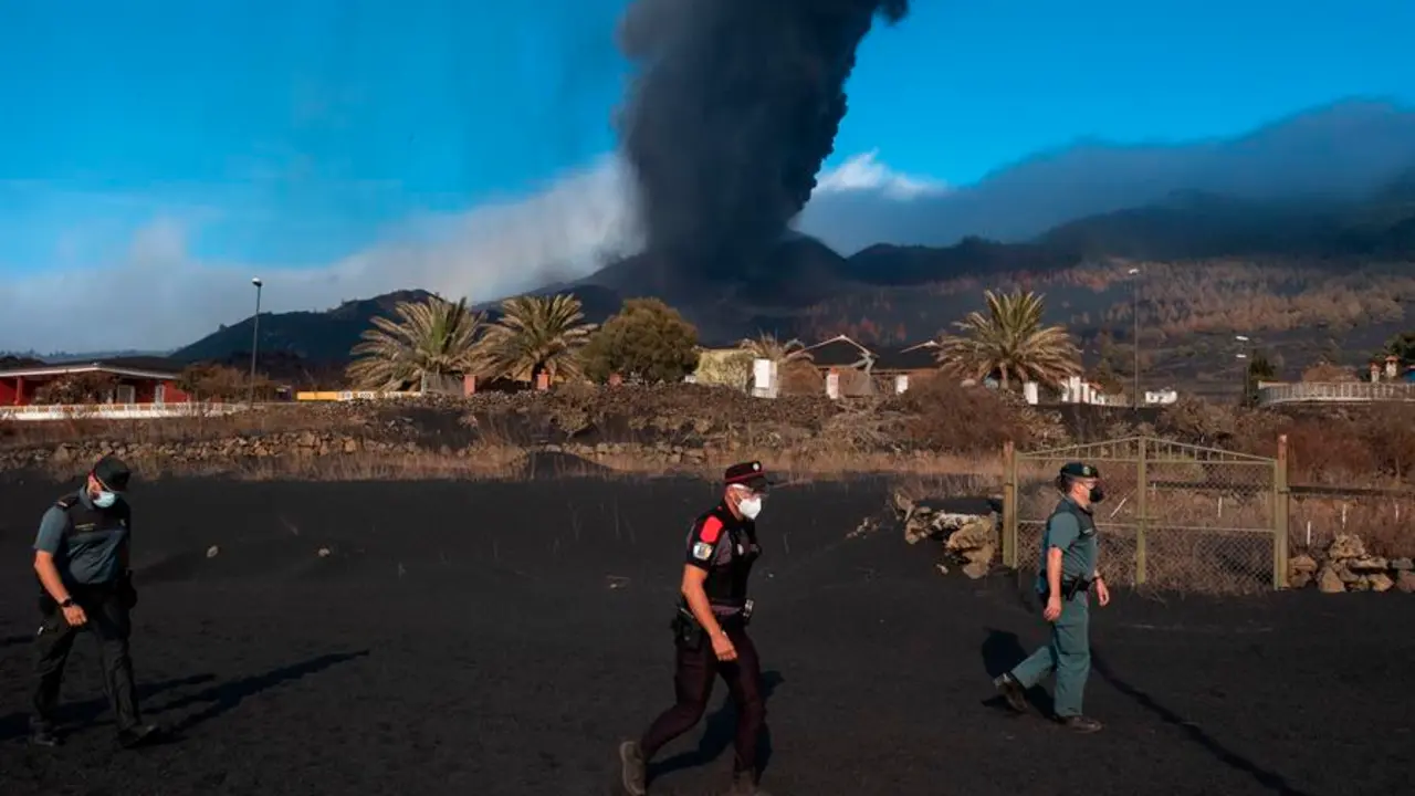 Un agente de la Polic&iacute;a Canarias y dos de la Guardia Civil patrullan este lunes por el barrio de Las Manchas, en La Palma, dentro de la zona evacuada por su proximidad al volc&aacute;n y a sus emisiones de lava, ceniza y piroclastos. EFE/Carlos de Sa&aacute;