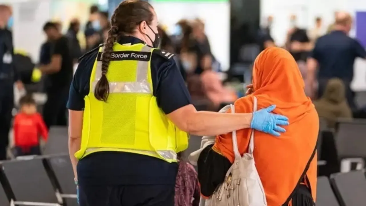 Un miembro de la Fuerza Fronteriza ayuda a una refugiada afgana a su llegada al aeropuerto de Heathrow en agosto. Fotograf&iacute;a: Dominic Lipinski / AFP / Getty Images