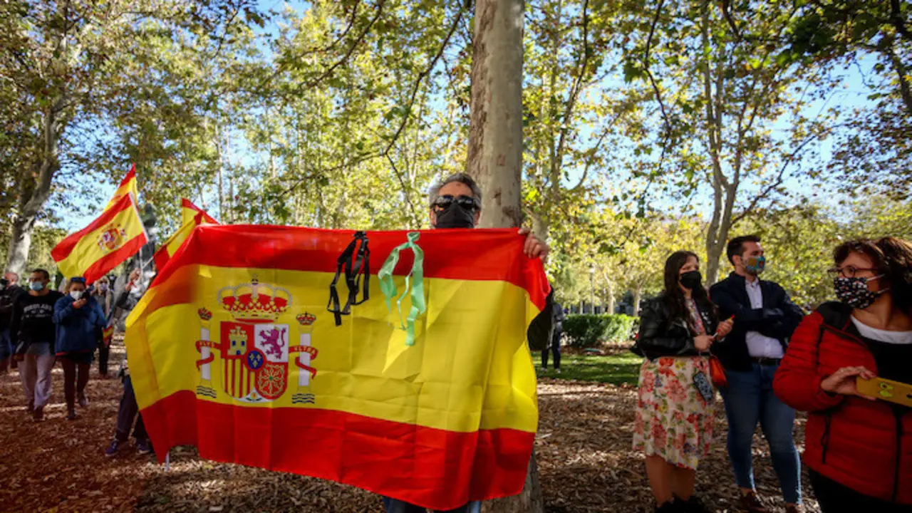 Varias personas se concentran con banderas de Espa&ntilde;a en apoyo a la figura de Felipe VI a las puertas del Palacio Real mientras se celebra el acto militar con motivo del D&iacute;a de la Fiesta Nacional o D&iacute;a de la Hispanidad, en Madrid (Espa&ntilde;a), a 12 de octubre de 2020. La celebraci&oacute;n este a&ntilde;o es mucho m&aacute;s &iacute;ntima sin el tradicional desfile por el Paseo de la Castellana, en un d&iacute;a en el que se conmemora la efem&eacute;ride hist&oacute;rica del descubrimiento de Am&eacute;rica por parte de Espa&ntilde;a.
12 OCTUBRE 2020;APOYO MONARQU&Iacute;A;REY;HISPANIDAD;FIESTA NACIONAL
Ricardo Rubio / Europa Press
  (Foto de ARCHIVO)
12/10/2020