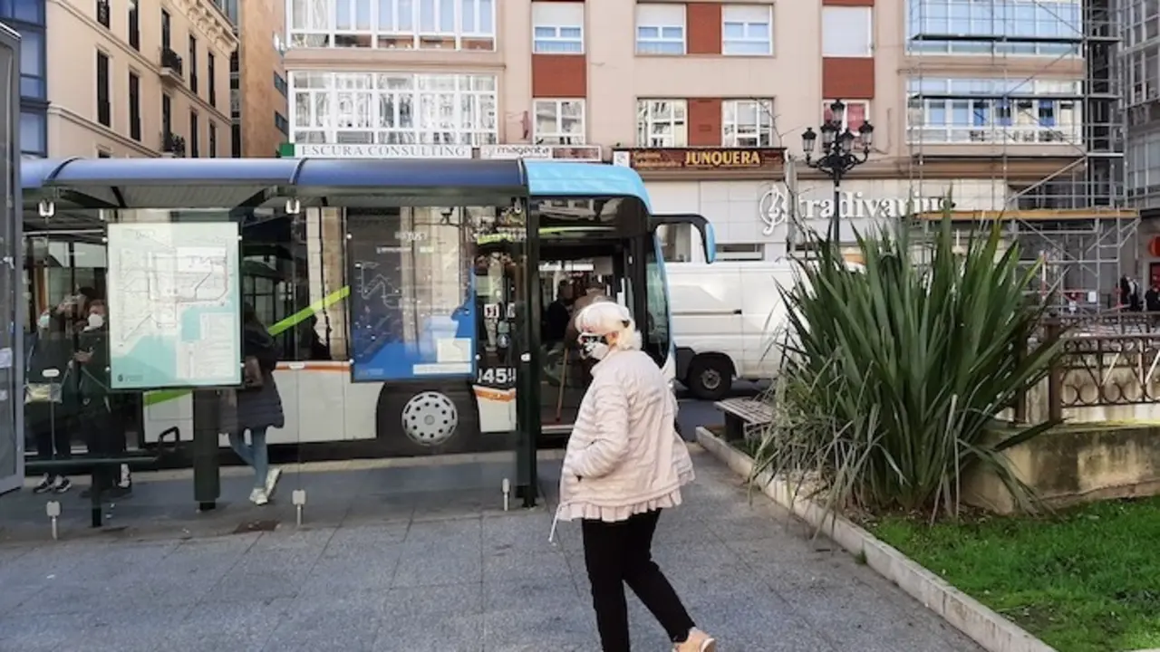 Una persona con mascarilla se dispone a tomar el bus en el centro de Santander. / S. D&iacute;az