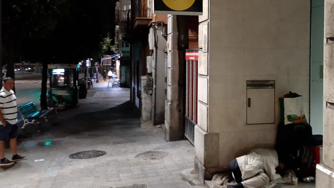 Una persona durmiendo en la entrada de un banco en Santander. / S. D&iacute;az