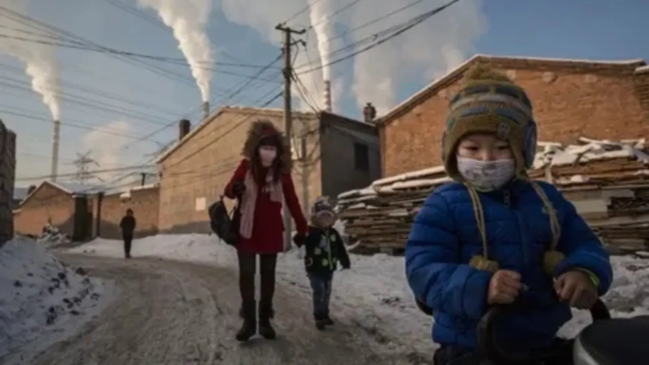 Los residentes de Shanxi usan m&aacute;scaras para protegerse mientras el humo sale de las pilas de carb&oacute;n en 2015. Fotograf&iacute;a: Kevin Frayer / Getty Images