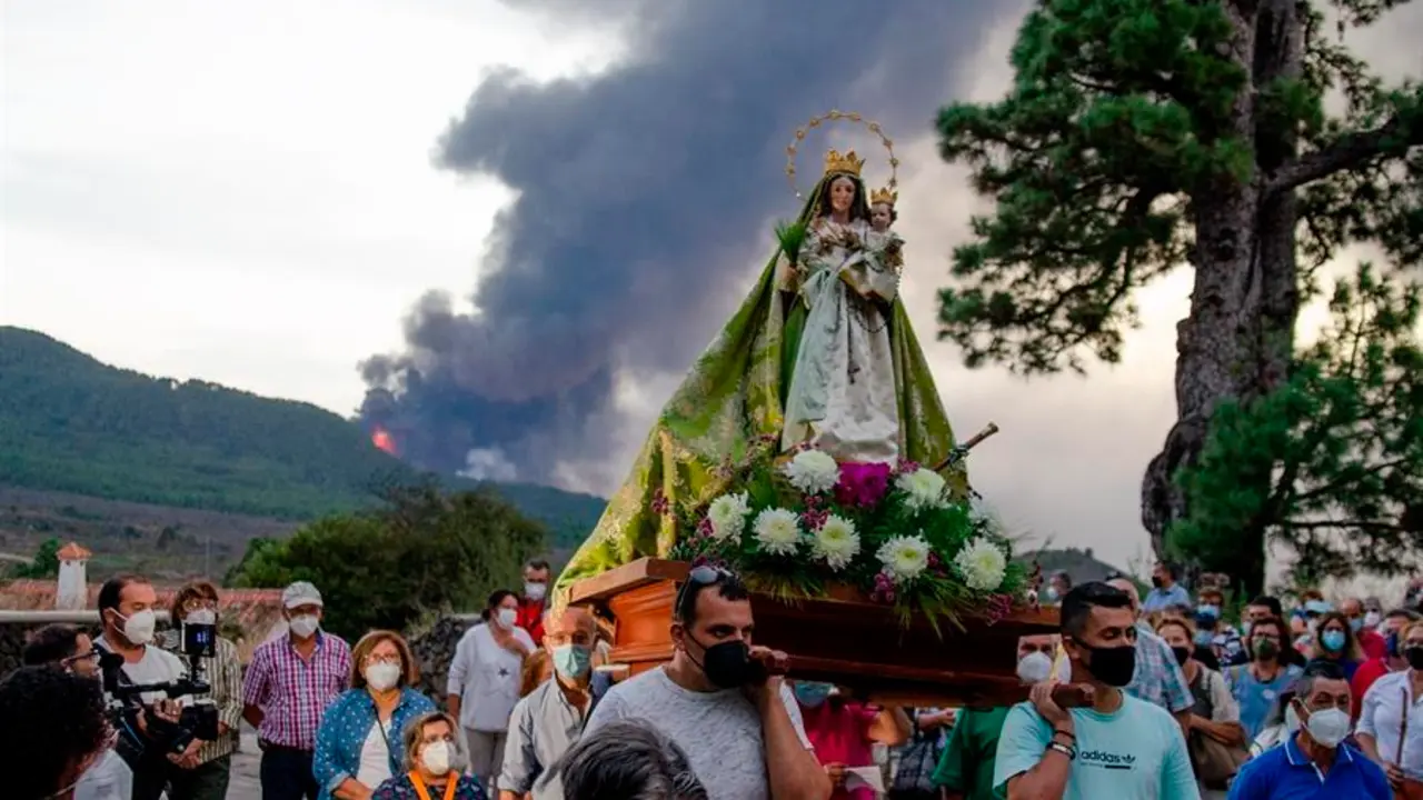 Procesi&oacute;n de la Virgen del Pino, en El Paso, con el volc&aacute;n al fondo, para pedir su intercesi&oacute;n en favor del cese de la acci&oacute;n devastadora de este volc&aacute;n cuando se cumple un mes de la erupci&oacute;n del Cumbre Vieja. EFE/Miguel Calero