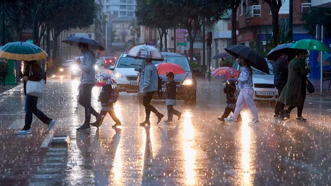 Varias personas cruzan una calle bajo la lluvia cuando el litoral sur de Valencia y norte de Alicante est&aacute; en preemergencia nivel naranja por lluvias durante hoy viernes y el fin de semana en la Comunitat Valenciana se presenta con lluvias durante el s&aacute;bado, mientras que para el domingo el cielo estar&aacute; poco nuboso y se espera un ligero aumento de las temperaturas m&aacute;ximas. EFE/ Natxo Franc&eacute;s