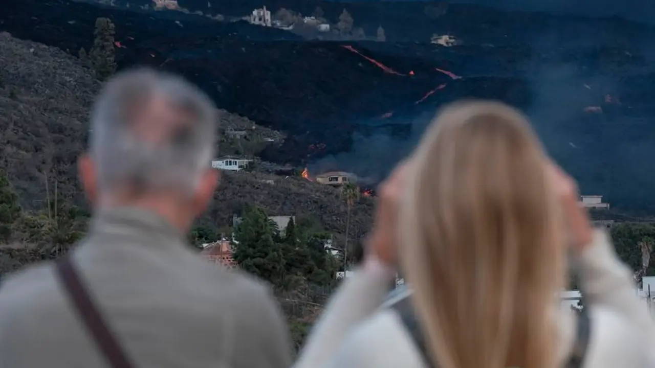 Vista del volc&aacute;n y la colada desde el municipio de Tazacorte, en la isla de La Palma, este viernes. Las pr&oacute;ximas horas ser&aacute;n decisivas para conocer el futuro de La Laguna y de otros barrios adyacentes, tanto de Los Llanos de Aridane como del vecino Tazacorte, evacuados desde el pasado mi&eacute;rcoles ante el incierto avance de la lava. Las dos coladas que el mi&eacute;rcoles avanzaron con velocidad y se unieron en una sola en el barrio de La Laguna est&aacute;n pr&aacute;cticamente "paradas" pero est&aacute;n recibiendo "mucho aporte de lava" en su parte trasera, tal y como confirman las c&aacute;maras termogr&aacute;ficas. El comit&eacute; cient&iacute;fico del Plan de Emergencias Volc&aacute;nicas de Canarias (Pevolca) prev&eacute; que tarde o temprano esas coladas, que han ido ganando en altura y anchura, prosigan su aproximaci&oacute;n al mar. EFE/ Angel Medina G.