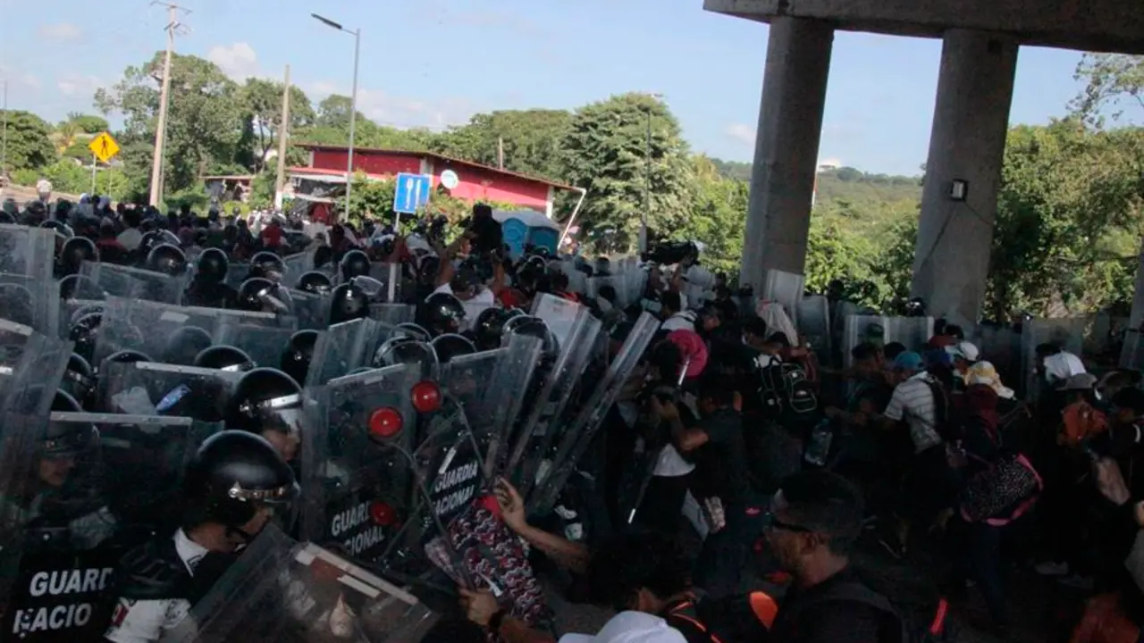Miembros de la Guardia Nacional chocan con un grupo de migrantes al intentar detener su caravana en el tramo carretero Tapachula- Viva M&eacute;xico, hoy, en el estado de Chiapas (M&eacute;xico). EFE/ Juan Manuel Blanco