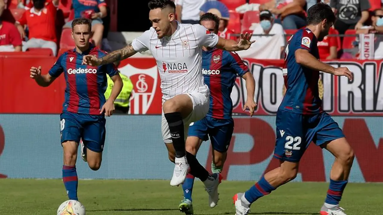 El jugador del Sevilla Ocampos y Melero del Levante luchan por el bal&oacute;n, durante el partido de LaLiga disputado este domingo en el estadio Sanchez Pizju&aacute;n de Sevilla. EFE/Jose Manuel Vidal.