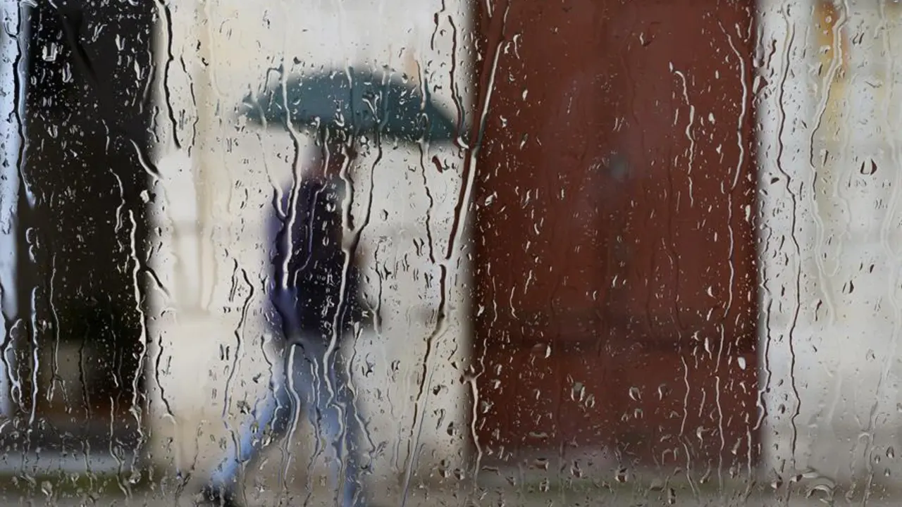 Un hombre camina bajo la lluvia por una calle de Santander. / Pedro Puente Hoyos