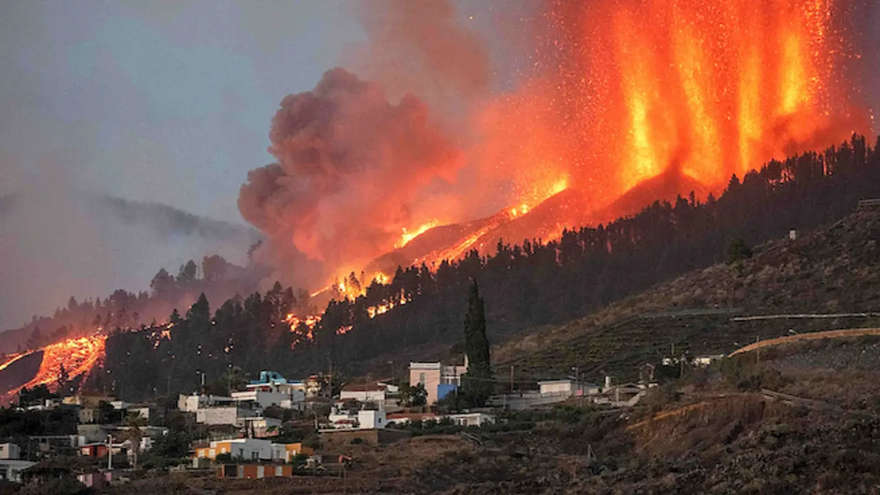 Mount Cumbre Vieja erupts in El Paso, spewing out columns of smoke, ash and lava as seen from Los Llanos de Aridane on the Canary island of La Palma on September 19, 2021. - The Cumbre Vieja volcano erupted on Spain's Canary Islands today spewing out lava, ash and a huge column of smoke after days of increased seismic activity, sparking evacuations of people living nearby, authorities said. Cumbre Vieja straddles a ridge in the south of La Palma island and has erupted twice in the 20th century, first in 1949 then again in 1971. (Photo by DESIREE MARTIN / AFP)