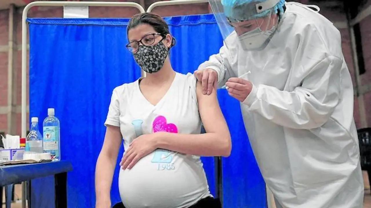 Una mujer embarazada recibe la vacuna contra el coronavirus. / AFP
