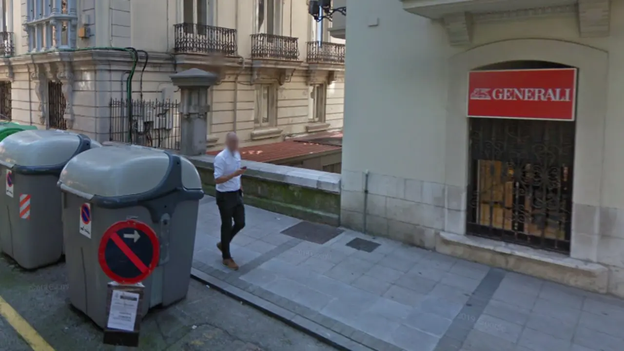 Una persona pasa por delante de los contenedores de basura en la calle Juan de la Cosa en Santander. / ALERTA
