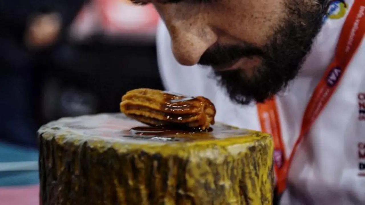 El chef Javier Garc&iacute;a Pe&ntilde;a huele el pincho "Churro de lechazo" del restaurante La Parrilla de San Lorenzo, que participa este lunes en el XVII Concurso Nacional de Pinchos celebrado en Valladolid. EFE/ Nacho Gallego