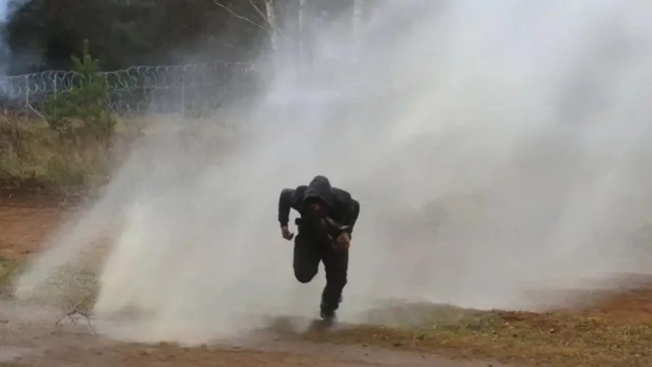 Un hombre huye de un ca&ntilde;&oacute;n de agua utilizado por agentes de la ley polacos en la frontera entre Belar&uacute;s y Polonia. Fotograf&iacute;a: Leonid Shcheglov / Belta / AFP / Getty