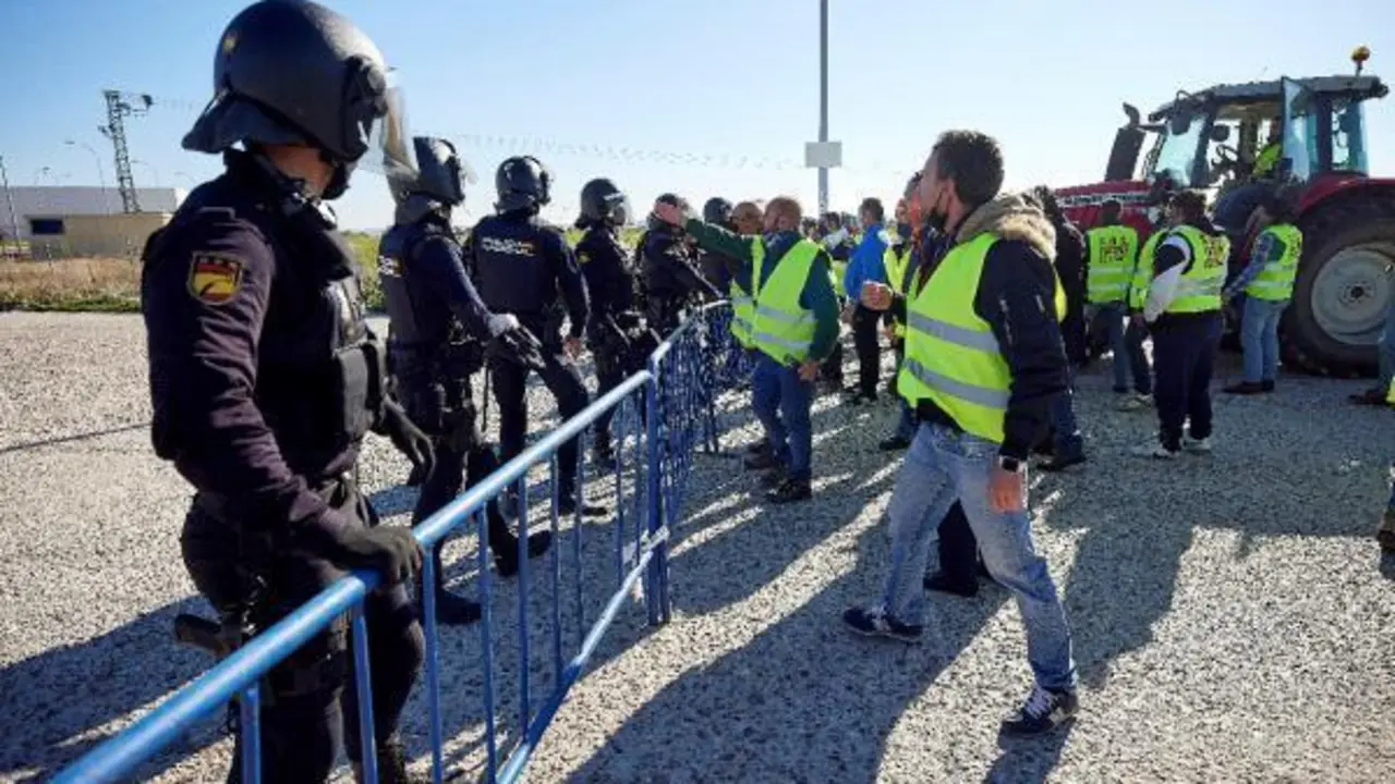 Agentes de la Polic&iacute;a Nacional durante los enfrentamientos con algunos de los manifestantes de la tractorada que este mi&eacute;rcoles han convocado los ganaderos de vacuno de leche en Talavera de la Reina (Toledo), para protestar por los precios bajos que reciben los productores por la leche a la empresas.EFE/ Manu Reino