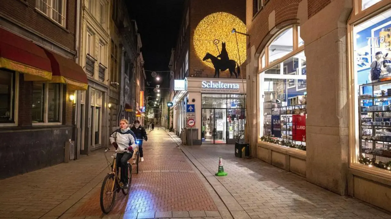 Personas montando en bicicleta junto a tiendas cerradas en &Aacute;msterdam, Pa&iacute;ses Bajos, el 28 de noviembre de 2021. La hora de cierre de todos los locales y eventos es entre las 17:00 y las 5:00 horas. (Pa&iacute;ses Bajos; Holanda) EFE/EPA/Evert Elzinga
