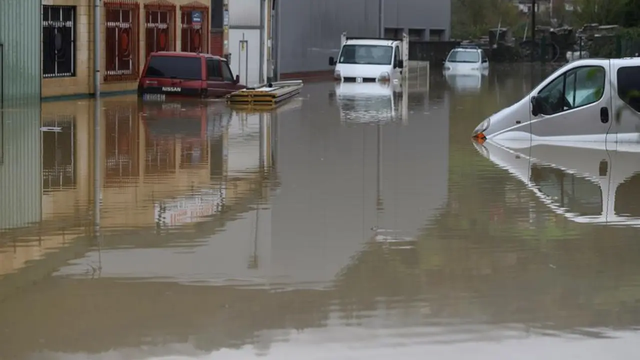 Varios veh&iacute;culos permanecen bajo el agua en el poligono industrial de Ampuero este lunes, debido a la crecida del r&iacute;o As&oacute;n.- EFE/Pedro Puente Hoyos
