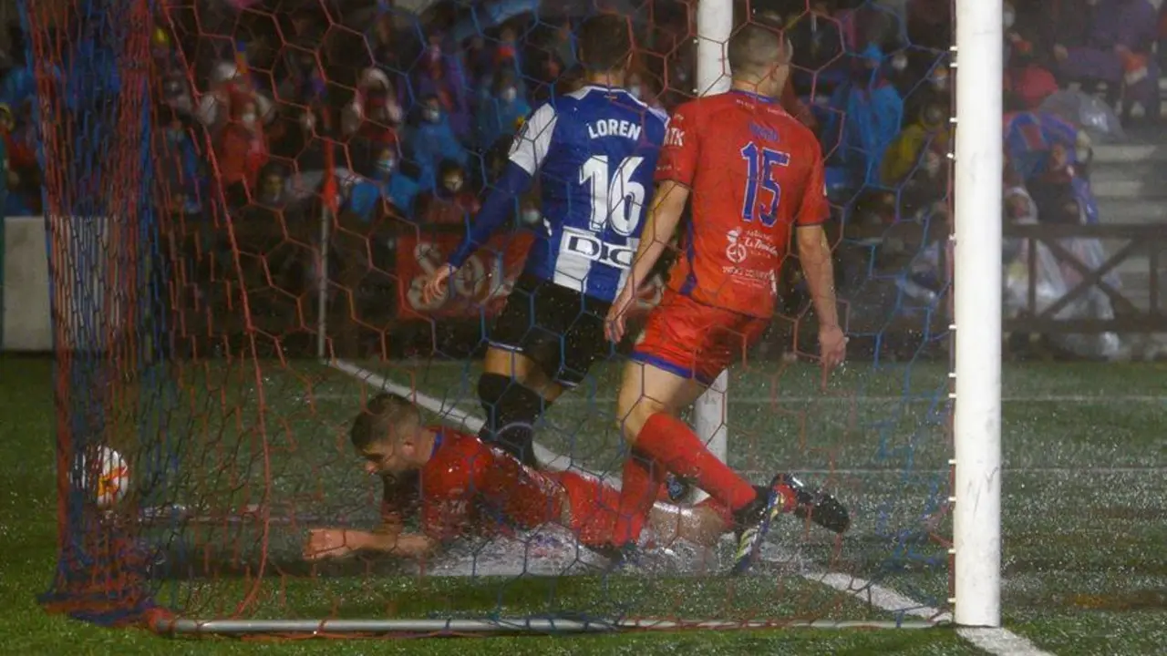 El jugador del Solares Medio Cudeyo, &Aacute;ngel Osl&eacute; (i), intenta que el bal&oacute;n no entre en la porter&iacute;a en el primer gol del Espanyol durante el partido de la la primera ronda de la Copa del Rey disputado este mi&eacute;rcoles en la localidad c&aacute;ntabra de Solares. EFE/Pedro Puente Hoyos