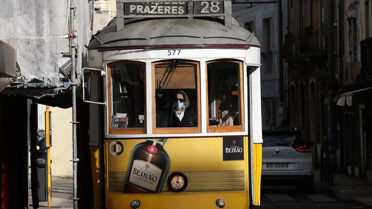 Un conductor con mascarilla conduce un tranv&iacute;a en Lisboa.