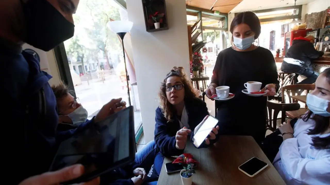 Una clienta muestra el c&oacute;digo QR del certificado de vacunaci&oacute;n al responale de un bar del barrio de Gracia de Barcelona. EFE/Marta P&eacute;rez