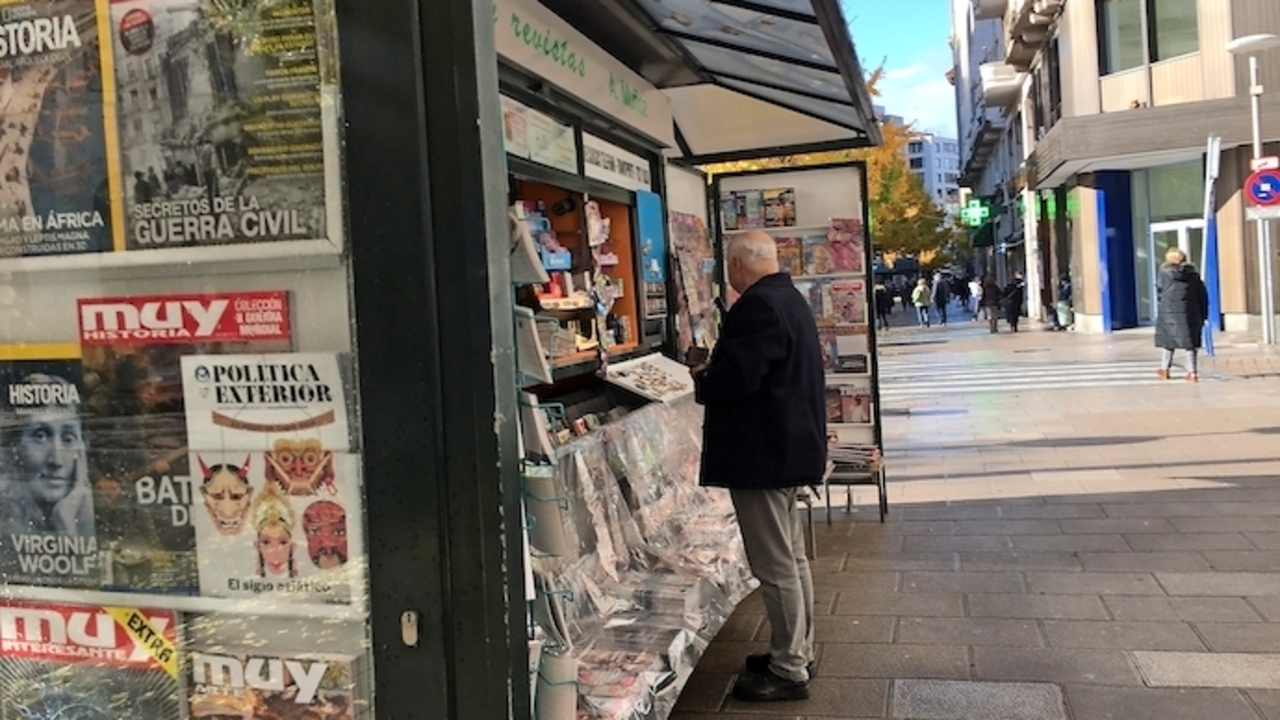Una persona sin mascarilla compra algo de leer en un kiosko de Santander. / ALERTA