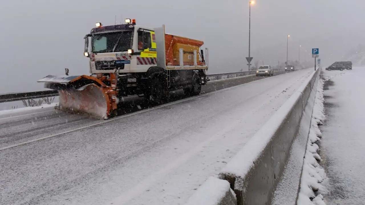 Una m&aacute;quina quitanieves quitando nieve de las carreteras.