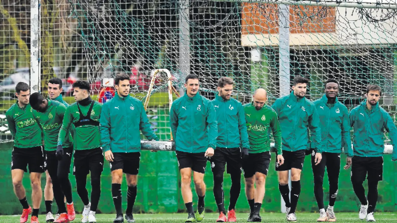 Los jugadores del Racing cargan una porter&iacute;a durante el entrenamiento. / Hardy