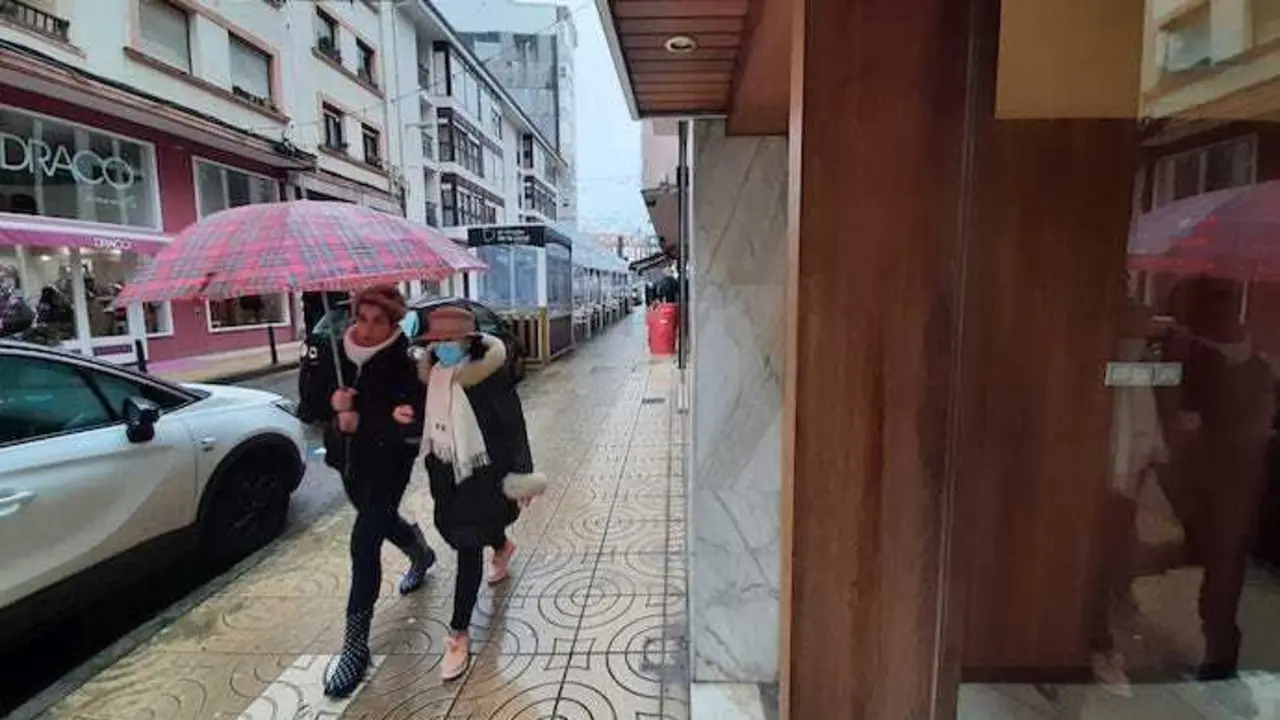 Dos personas con y sin mascarilla por Torrelavega.
