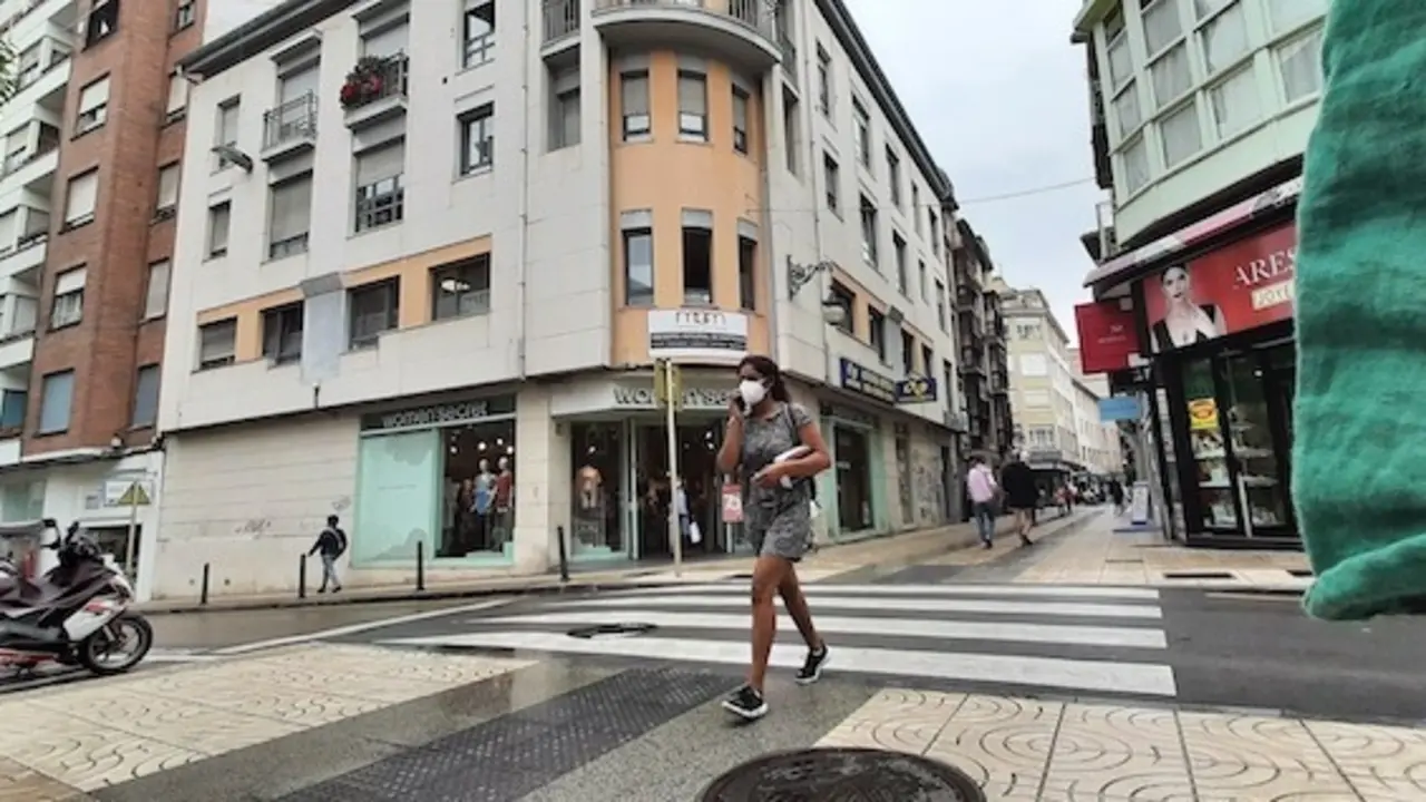Una mujer con su m&oacute;vil transita por la calle Consolaci&oacute;n de Torrelavega. / ALERTA