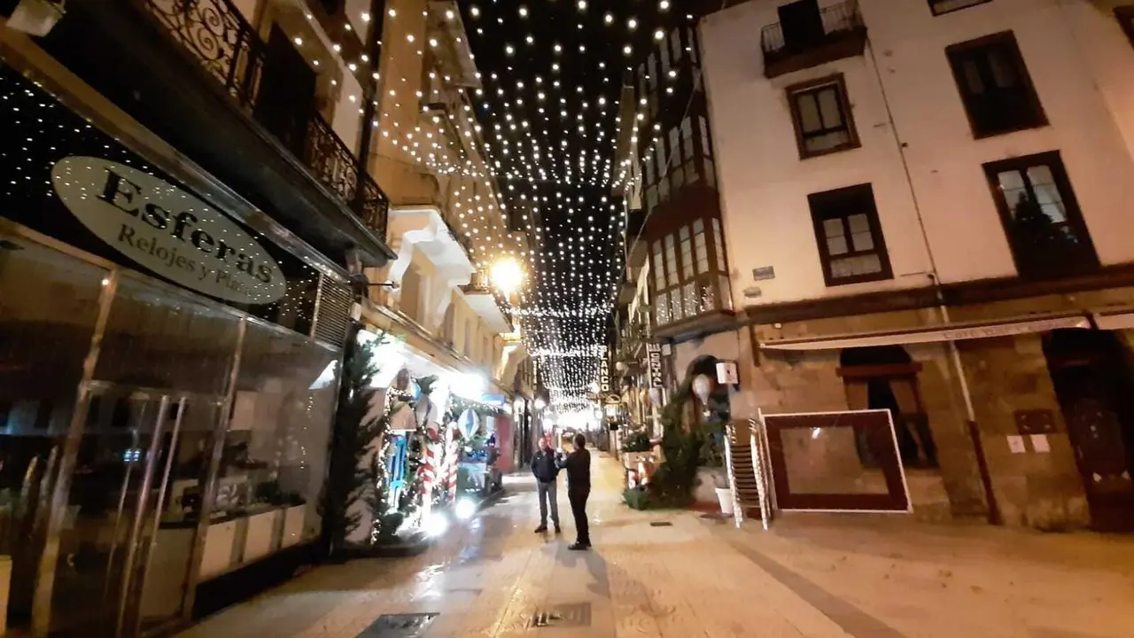 Dos personas se hacen una foto en la calle Consolaci&oacute;n de Torrelavega con las luces navide&ntilde;as. / ALERTA