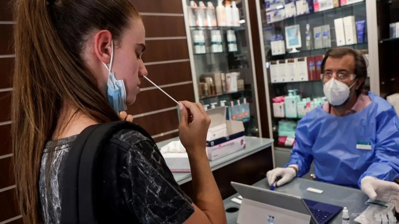 Un farmac&egrave;utico explica y supervisa la realizaci&oacute;n de autotests de ant&iacute;genos en una imagen de archivo. EFE/Quique Garcia