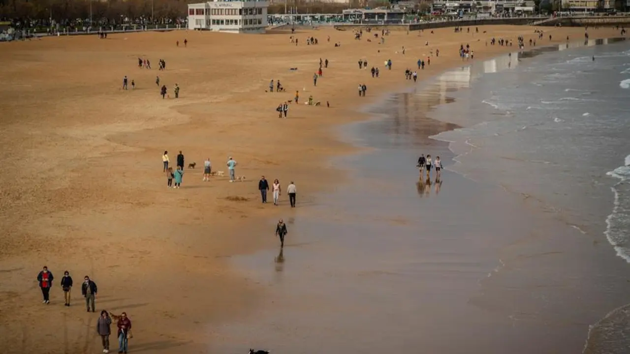 Decenas de personas pasean este lunes por la playa de El Sardinero, en Santander. / ROM&Aacute;N G. AGUILERA