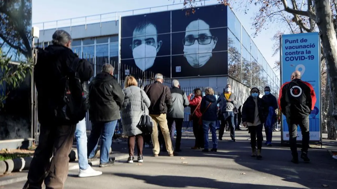 Decenas de ciudadanos guardan su turno en cola para accecer al centro de vacunaci&oacute;n instalado en la Fira de Barcelona este lunes. EFE/Quique Garcia