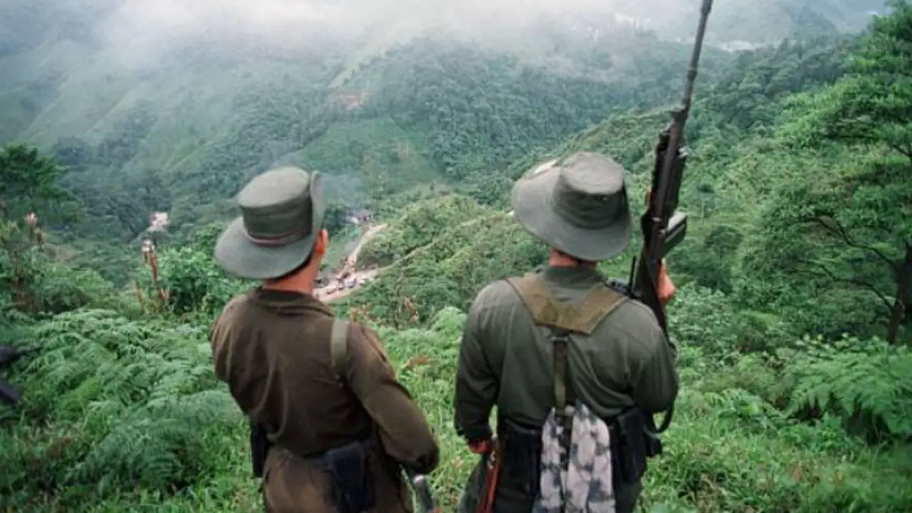 Dos soldados armados de las Fuerzas Armadas Revolucionarias de Colombia (FARC) vigilan el paso de Berl&iacute;n.