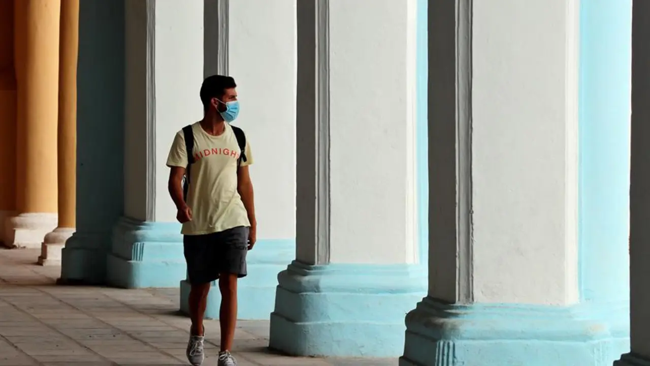 Un joven camina con mascarilla por unos portales en La Habana Vieja (Cuba). EFE/ Ernesto Mastrascusa/Archivo