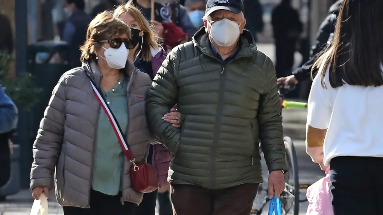 Varias personas transitan con su mascarilla.