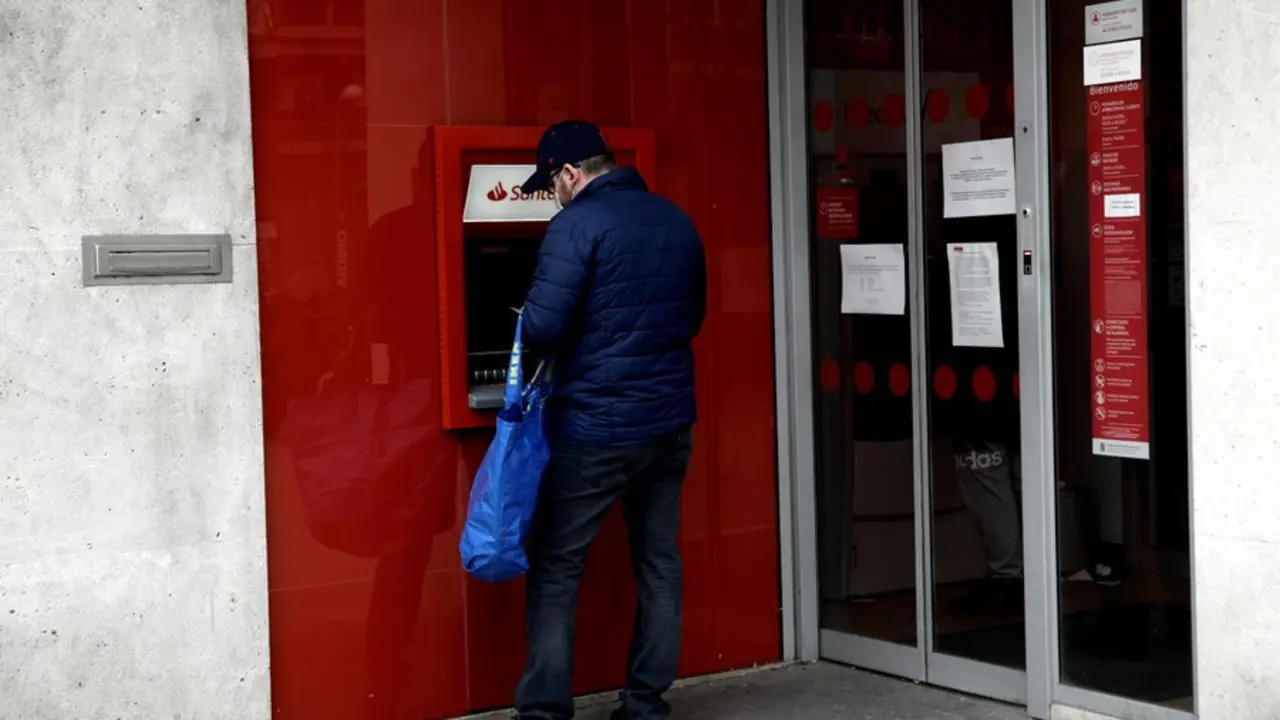 Un hombre saca dinero de un cajero del Banco Santander. / EP