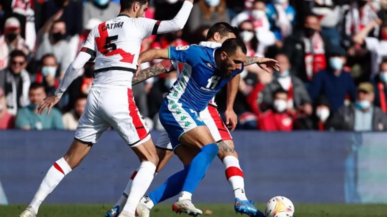 El jugador del Real Betis Borja Iglesias y el futbolista del Rayo Vallecano Alejandro Catena disputan el bal&oacute;n durante un partido en el Estadio de Vallecas de LaLiga Santander 2021-2022. - Oscar J. Barroso / AFP7 / Europa Press