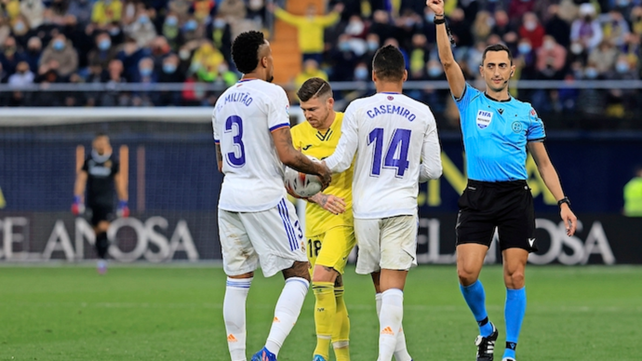VILLARREAL, 12/02/2022.-El defensa del Real Madrid &Eacute;der Milit&atilde;o (i) recibe tarjeta amarilla, durante el partido de la jornada 24 de La Liga Santander hoy s&aacute;bado en el Estadio de la Cer&aacute;mica.- EFE / Domenech Castell&oacute;
