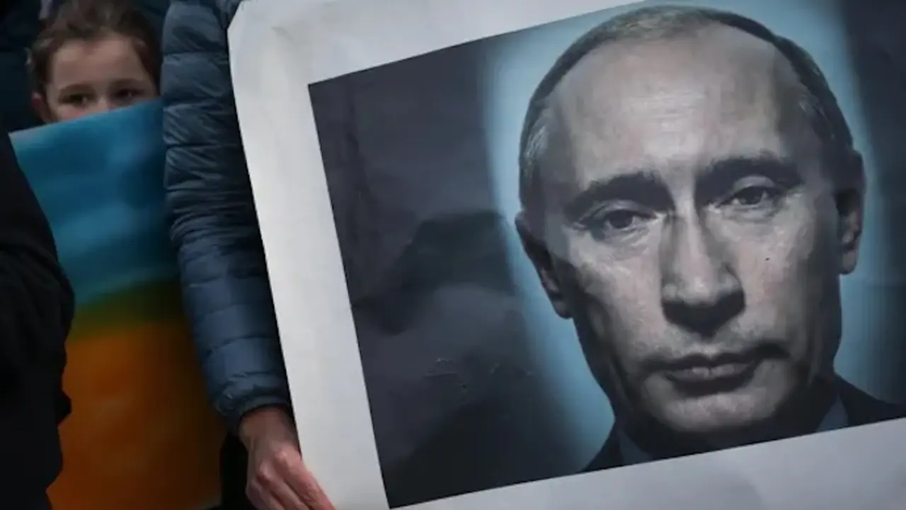 Una mujer sostiene una pancarta de Vladimir Putin mientras participa en una protesta por la paz en Lisboa, Portugal, el s&aacute;bado. Fotograf&iacute;a: Rodrigo Antunes / EFE