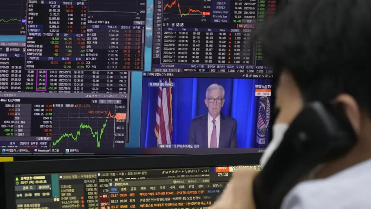 Un comerciante de divisas observa los monitores frente a las pantallas que muestran el &iacute;ndice de precios de acciones compuesto de Corea (KOSPI) y el tipo de cambio entre el d&oacute;lar estadounidense y el won surcoreano, a la derecha, en la sala de operaciones de divisas de la sede del KEB Hana Bank en Se&uacute;l, Sur. Corea, jueves 17 de marzo de 2022. Los precios de las acciones asi&aacute;ticas han subido por segundo d&iacute;a despu&eacute;s de que la Reserva Federal anunciara su primera subida de tipos de inter&eacute;s desde 2008 y China prometiera apoyo a sus sectores inmobiliario y de Internet. (Foto AP/Ahn Young-joon)