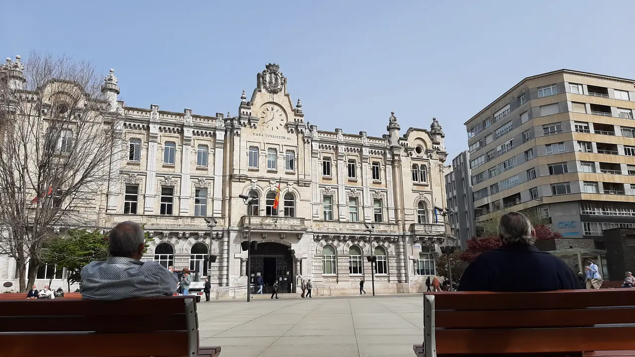 Dos personas sentadas en la plaza del Ayuntamiento de Santander. / ALERTA
