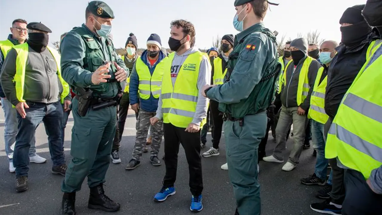 Agentes de la Guardia Civil dialogan con transportistas que cortaron este viernes durante aproximadamente media hora la A-6.